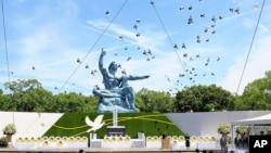 Doves fly over the Peace Statue during a ceremony to mark the 79th anniversary of the US atomic bombing at the Peace Park in Nagasaki, Japan, Aug. 9, 2024. 