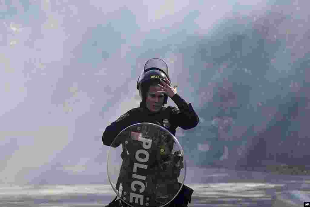 A police officer runs out of a cloud of gas during a demonstration in opposition to a new police training center in Atlanta, Georgia, United States.