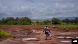 Pi'ilani Taniguchi Butler membawa seember tanah liat basah ke hamparan garam keluarganya di Hanapepe, Hawaii, Rabu, 12 Juli 2023. Lapisan garam atau "loi" dihaluskan menggunakan bebatuan sungai. (AP/Jessie Wardarski)