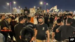 Protesters gather in Baghdad's Tahrir Square, carrying Iraqi flags and images of influential Shiite cleric Muqtada al-Sadr, July 22, 2023, following reports of the burning of a Quran carried out by an ultranationalist group in front of the Iraqi Embassy in Copenhagen, Denmark.