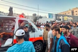 People gather around an ambulance damaged by a reported Israeli attack in front of Al-Shifa Hospital in Gaza City on November 3, 2023. (Photo: AFP)