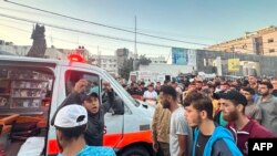 2023年11月3日，在加沙市Al-Shifa医院前，人们聚集在一辆在以色列袭击中损坏的救护车周围。（法新社）