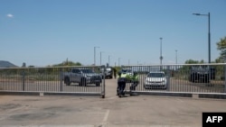 Security guards open the gate at Bakubung Platinum Mine in Ledig on December 8, 2023, where mineworkers are staging an underground protest. 