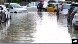 A man wades through a flooded street in Campi di Bisenzio, Italy, Nov. 3, 2023. Record-breaking rain caused floods in Tuscany as Storm Ciaran pushed into Italy overnight Friday, trapping people in homes, inundating hospitals and flipping cars.