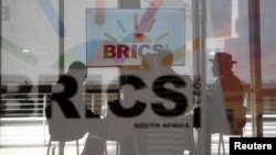 Delegasi Afrika Selatan duduk di balik kaca berlogo BRICS saat KTT BRICS diadakan di Johannesburg, Afrika Selatan, 23 Agustus 2023. (Foto: REUTERS/Alet Pretorius)
