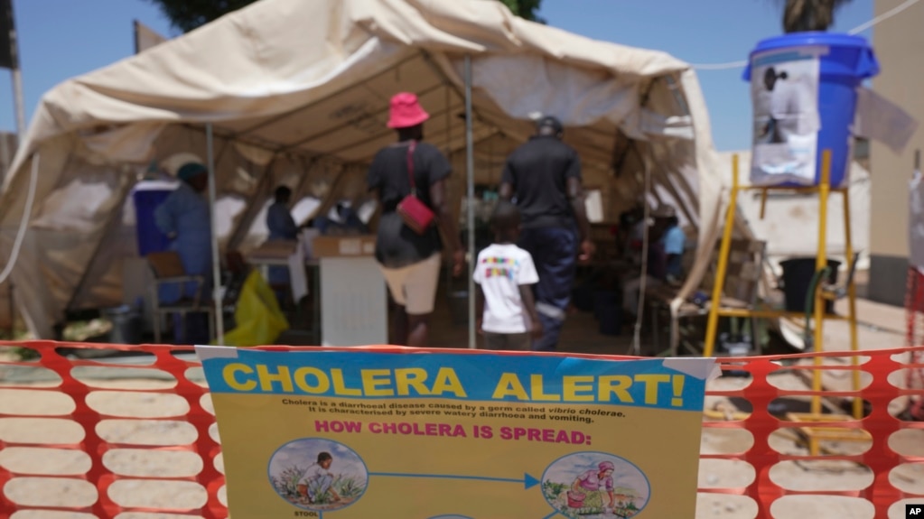 FILE - A family is seen entering a tent set up for suspected cholera patients at a clinic in Harare, Zimbabwe, Nov. 18, 2023.