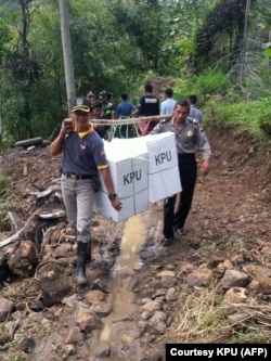 FILE - Pekerja mengantarkan kotak suara ke desa-desa terpencil di Yalimo, Provinsi Papua pada 2019. (Foto: Courtesy/Komisi Pemilihan Umum/AFP)