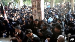 People gather near pictures of those who died in an October 2022 stampede at the Kanjuruhan stadium in Malang, Indonesia, marking the one-year anniversary of the deadly incident in Malang, East Java province, Indonesia, Oct 1, 2023.