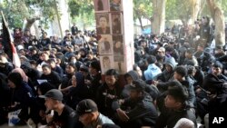 Warga berkumpul di Stadion Kanjuruhan, Malang, dengan membawa foto para korban ketika memperingati satu tahun tragedi di stadion tersebut yang menewaskan 135 orang, pada 1 Oktober 2023. (Foto: AP/Hendra Permana)