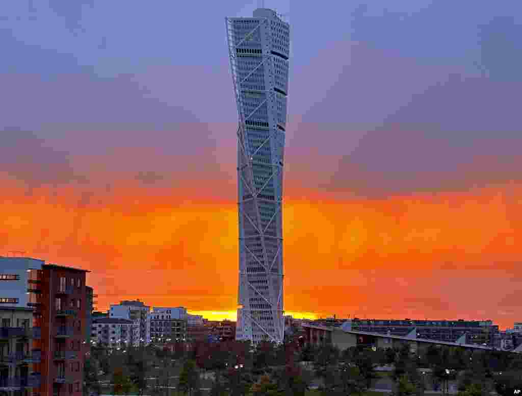 The sun sets behind the &#39;Turning Torso&#39; skyscraper in Malmoe, Sweden.