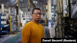 Walter Banegas, 28, originally from Honduras, poses for a picture during his shift at the Pace Industries aluminum injection molding plant, his formal job after settling in Mexico as a refugee, in Saltillo, Mexico October 16, 2023. (REUTERS/Daniel Becerril)