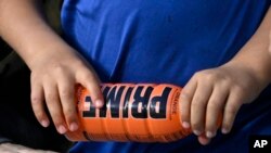 Seorang anak tampak memegang botol minuman bernergi PRIME dalam sebuah acara di Los Angeles, pada 31 Maret 2023. (Foto: AP/Mark J. Terril)