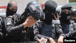 A police officer washes his face as protesters gather near the Turkish Embassy during a demonstration against cutting Iraq&#39;s water supply, in Baghdad.