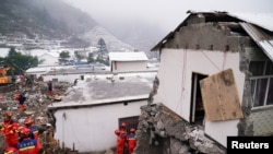 Petugas penyelamat mencari korban di dekat rumah-rumah yang rusak akibat tanah longsor yang melanda desa Liangshui di wilayah Zhenxiong, Zhaotong, provinsi Yunnan, China, 23 Januari 2024. (cnsphoto via REUTERS).