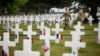 Soldiers walk by headstones in the American Cemetery in Colleville-sur-Mer, Normandy, June 5, 2023.