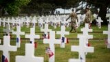 Soldiers walk by headstones in the American Cemetery in Colleville-sur-Mer, Normandy, June 5, 2023.