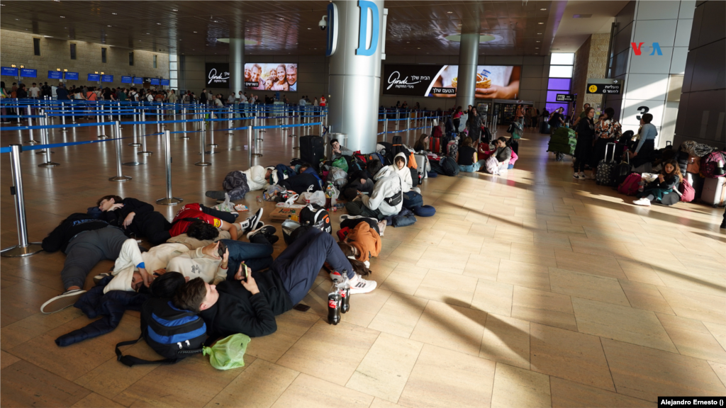 Turistas y ciudadanos extranjeros, la mayoría latinoamericanos, descansan en el piso del aeropuerto internacional de Telaviv mientras esperan regresar a sus países en vuelos repatriación desde un Israel en guerra, el 13 de octubre de 2023.