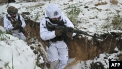 Militares ucranianos de la 43.ª Brigada Mecanizada vestidos con camuflaje de nieve participan en un entrenamiento militar en un lugar no revelado de la región de Kharkiv el 1 de diciembre de 2023, en medio de la invasión rusa de Ucrania.