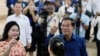 Cambodian Prime Minister Hun Sen, right, shows off his ink-stained finger, together with his wife Bun Rany, left, after they cast their ballots at a polling station in Takhmua, southeast of Phnom Penh, Cambodia, July 23, 2023. 