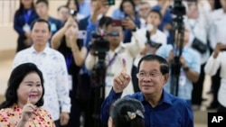 ကမ္ဘောဒီးယားဝန်ကြီးချုပ်ဟွန်ဆန်နဲ့ ဇနီး Bun Rany တို့ မဲပေးအပြီး မှင်စွန်းနေတဲ့လက်ညှိုးတွေပြသနေပုံ၊ ဇူလိုင် ၂၃၊ ၂၀၂၃
