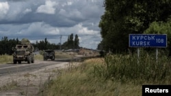 Ukrainian soldiers ride military vehicles from a crossing point at the border with Russia in the Sumy region of Ukraine on Aug. 13, 2024.