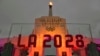 FILE - An LA 2028 sign is seen in front of the Olympic cauldron at the Los Angeles Memorial Coliseum, Sept. 13, 2017. 