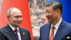 Presiden China Xi Jinping dan Presiden Rusia Vladimir Putin berjabat tangan sebelum melangsungkan pertemuan di Beijing, pada 16 Mei 2024. (Foto: Sergei Bobylev, Sputnik, Kremlin Pool Photo via AP, File)