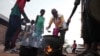 People prepare food in a Khartoum neighborhood Friday, June 16, 2023.