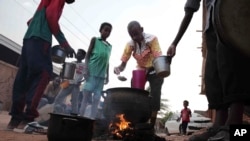 People prepare food in a Khartoum neighborhood Friday, June 16, 2023.
