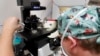 Lab staff place small petri dishes holding several embryos onto a microsope stand and adjust the small pipettes used to extract cells from each embryo to test for viability at the Aspire Houston Fertility Institute, Feb. 27, 2024, in Houston.