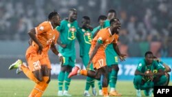 Basani ba Côte d'Ivoire #20 Christian Kouame (G) na #17 Serge Aurier (D) bazali kosepaela nsima na kopolisa Senegal na 8e ya CAN, na stade Charles Konan Banny na Yamoussoukro, Côte d'Ivoire, 29 sanza ya yambo 2024. 