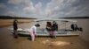 Peneliti dari Mamiraua Institute for Sustainable Development mengambil bangkai lumba-lumba yang telah mati di Danau Tefe, negara bagian Amazonas, Brazil, pada 1 Oktober 2023. (Foto: Reuters/Bruno Kelly)