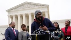 FILE - FILE - Evan Milligan, center, plaintiff in Merrill v. Milligan, an Alabama redistricting case, speaks with members of the press following oral arguments outside the Supreme Court on Capitol Hill in Washington, Oct. 4, 2022. 