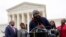 FILE - FILE - Evan Milligan, center, plaintiff in Merrill v. Milligan, an Alabama redistricting case, speaks with members of the press following oral arguments outside the Supreme Court on Capitol Hill in Washington, Oct. 4, 2022. 