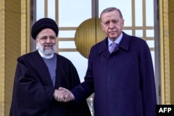 Presiden Turki Recep Tayyip Erdogan (kanan) berjabat tangan dengan Presiden Iran Ebrahim Raisi (kiri) saat upacara penyambutan di Ankara, 24 Januari 2024. (Adem ALTAN / AFP)