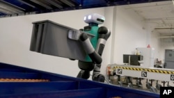 FILE - Agility Robotics' warehouse robot Digit performs maneuvers at the company's office in Pittsburgh, Aug. 16, 2023. Agility co-founder Jonathan Hurst makes a point of describing Digit as human-centric, not humanoid.