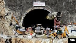 Rescue workers stand at an entrance of the under construction road tunnel, days after it collapsed in the Uttarkashi district of India's Uttarakhand state, Nov. 18, 2023. 