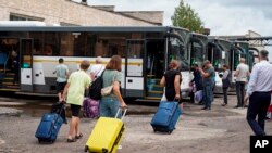 На оваа фотографија објавена од Владата на регионот Курск во Русија преку нивниот канал на Телеграм, 9 август 2024 година, роднини на деца од регионот Курск носат куфери, помагајќи им да заминат на одмор во московскиот регион.