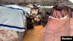 A displaced Sudanese woman rests inside a shelter at Zamzam camp, in North Darfur, Sudan, Aug. 1, 2024.