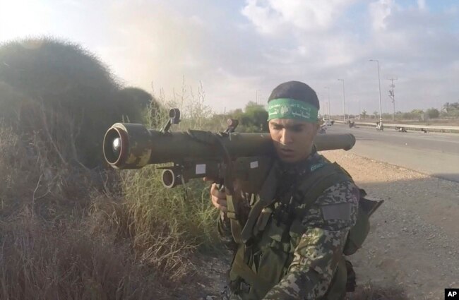 In this image from video taken Oct. 7, 2023, a Hamas fighter holds a Russian-designed 9M32 Strela anti-aircraft weapon. An Associated Press analysis of combat photos shows Hamas has amassed a patchwork arsenal of weapons from around the world.