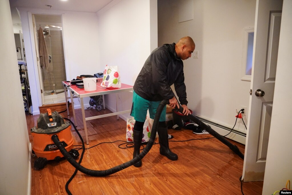 Carlos Ogando bombea agua desde el sótano inundado de la casa que comparte con su esposa Yas, en Hole, uno de los barrios más bajos del distrito de Brooklyn en la ciudad de Nueva York.