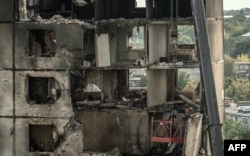 Ukrainian emergency workers inspect a heavily damaged residential building following a recent missile attack in Kharkiv, on Aug. 31, 2024.