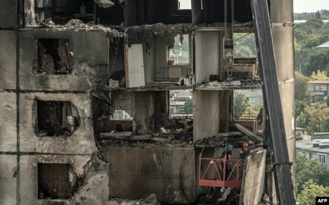 Ukrainian emergency workers inspect a heavily damaged residential building following a recent missile attack in Kharkiv, on Aug. 31, 2024.