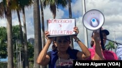 Una mujer participa en una protesta en plaza Venezuela, en Caracas para exigir derechos políticos en medio de la conmemoración de los 66 años de la caída del dictador Marcos Pérez Jiménez