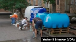 在乌克兰尼科波尔，由于城市供水管道近乎枯竭，居民们只能从水箱中取水。(2023年6月26日)