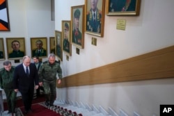 Russian President Vladimir Putin, center, and Russian military officials arrive at the headquarters of Russia's Southern Military District in Rostov-on-Don, Russia, Nov. 9, 2023. (Gavriil Grigorov, Sputnik, Kremlin Pool Photo via AP)