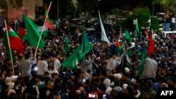 Palestinians prisoners (wearing gray) cheer among supporters after being released from Israeli jails in exchange for hostages released by Hamas from the Gaza Strip, in Ramallah in the occupied West Bank early on Nov. 26, 2023.