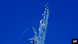 An Indian Air Force fighter aircraft Sukhoi Su-30 fires flares during Air Force Day celebrations at Sangam, the holy confluence of river Ganga, Yamuna and the mythical Saraswati, in Prayagraj.