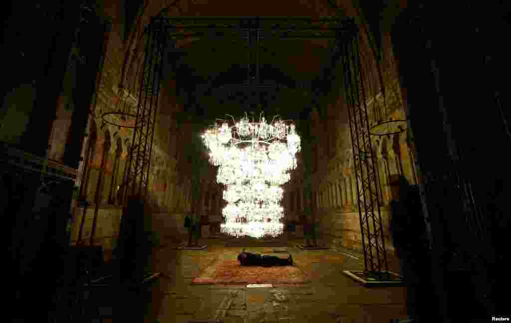 A photographer takes pictures of Chinese artist Al Weiwel&rsquo;s Illuminated Bottle Rack displayed in the Chapter House room of Durham Cathedral during the biennial Lumiere photocall in Durham, Britain, Nov. 15, 2023.