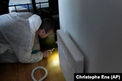 Pest control technician Lucas Pradalier looks for bedbugs in a Paris apartment, Wednesday, Oct. 4, 2023. (AP Photo/Christophe Ena)